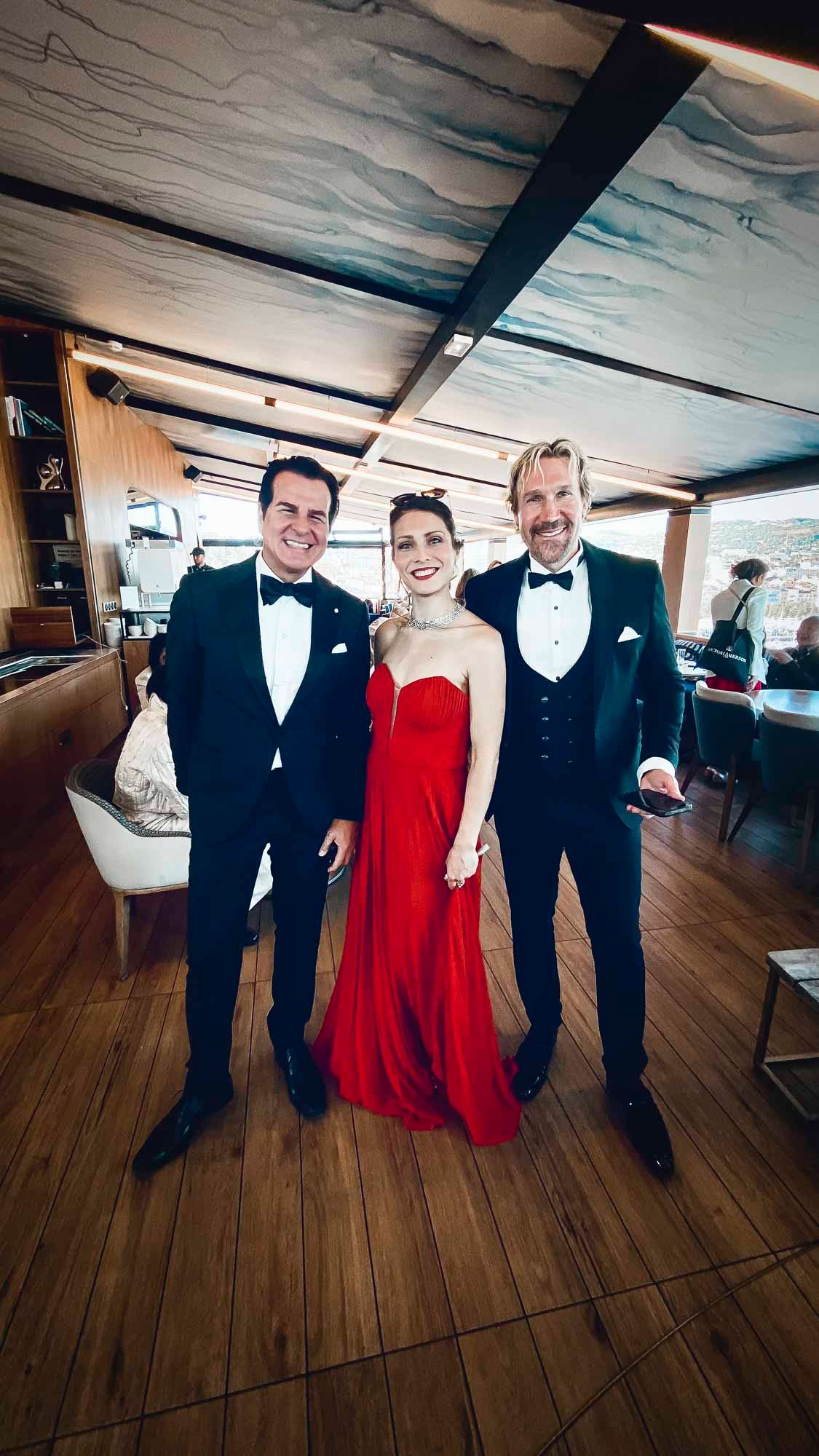 Nicole Tschaikin im roten Abendkleid zwischen Vincent DePaul und David A.R. White in Cannes